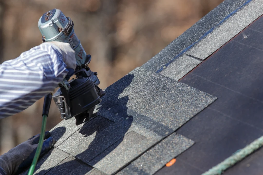 roofing shingles being installed with power tools